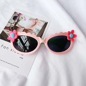 Detail einer pinkfarbenen Kinder-Sonnenbrille mit gewelltem Rahmen und Blumendekor