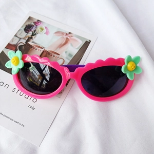 Detail der rosa Blumen-Sonnenbrille für Kinder mit Wellenrahmen auf weißem Stoff