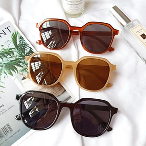 Chic oversized geometric sunglasses in brown, beige, and black on aesthetic background