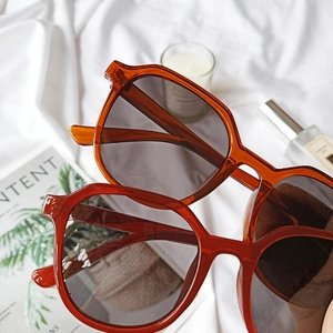 Close-up of retro oversized sunglasses with transparent orange and deep red frames