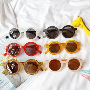 Vue à plat de lunettes de soleil rondes pour enfants en plusieurs couleurs et finitions