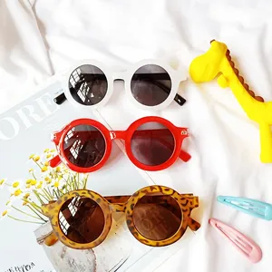 Vue détaillée de lunettes de soleil rondes pour enfants en blanc, rouge et léopard