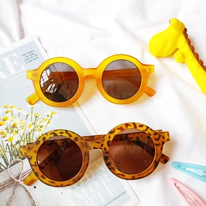 Détail de lunettes de soleil rondes pour enfants en orange et léopard avec protection UV