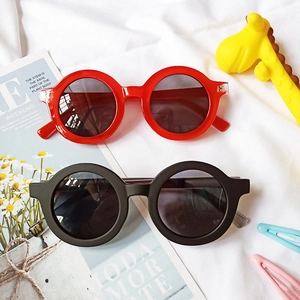 Vue à plat de lunettes de soleil rondes pour enfants en rouge et noir avec décor