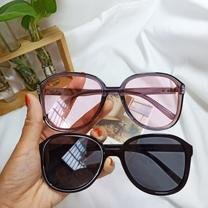 Detail view of purple and black oversized oval sunglasses featuring printed leg specs