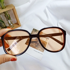 Detail of retro oversized sunglasses with black frame and orange inner rim accent