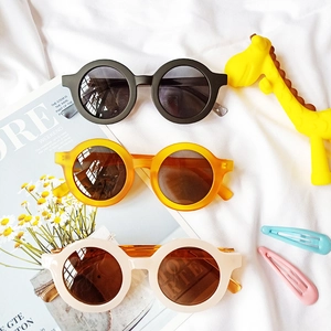 Trois paires de lunettes de soleil rondes pour enfants en noir, orange et crème