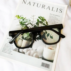 Lunettes carrées noires anti-lumière bleue sur un fond de magazine minimaliste
