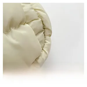 Detailed close-up of premium ivory quilted fabric with a soft satin finish and stitching