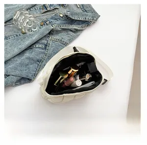 Detailed interior capacity showing daily essentials in a white quilted crossbody bag