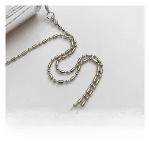 Macro shot of silver metal chain strap with alternating round bead and oval tube design