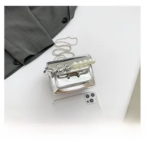 Mini silver patent leather bag size comparison with smartphone and pearl handle