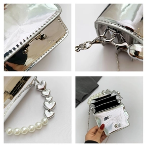 Detail of silver mirror mini bag showing pearl heart handle and multi-layer interior