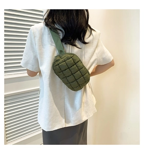 Back view of a model wearing a deep green quilted nylon cloud-style crossbody bag