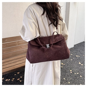 Detail of vintage suede shoulder bag with metal buckle closure and smooth matte texture