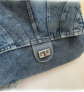 Vue détaillée du sac en denim avec fermoir rotatif en métal argenté et surpiqûres blanches