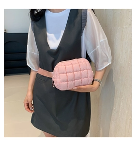 Detail view of pink quilted nylon crossbody bag showing texture and adjustable strap