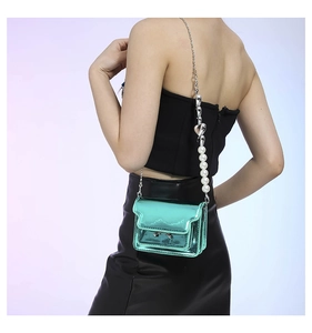 Detail of mint green patent leather mini bag with pearl chain and heart charm
