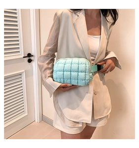 Close-up of mint green quilted puffer belt bag with adjustable strap and buckle