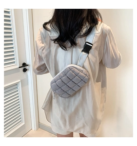 Detail of grey quilted crossbody bag with adjustable strap and matte nylon texture