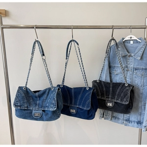 Détail de sacs cabas en denim avec bandoulières en chaîne et fermoir pivotant en trois couleurs