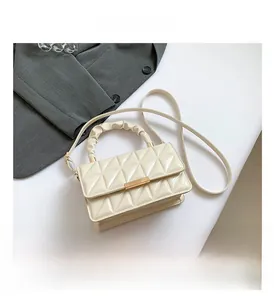 Vue détaillée du sac en cuir verni crème avec poignée à froufrous et fermoir doré