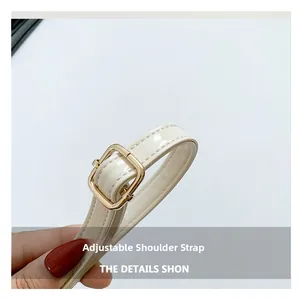 Gros plan sur la bandoulière réglable en cuir verni beige avec boucle dorée