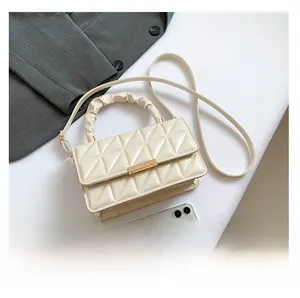 Détails de l'aspect matelassé vernis crème du sac à main avec son fermoir doré chic