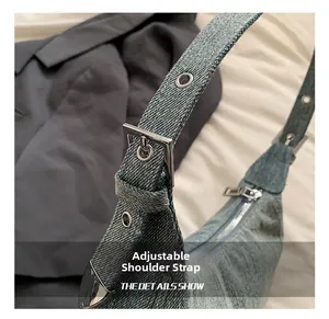 Close-up of adjustable denim shoulder strap with silver metal eyelets and square buckle