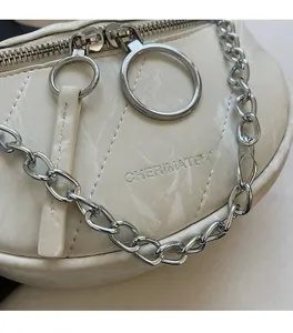 Detail of white marble pattern crossbody bag with thick silver chain and metal ring zipper