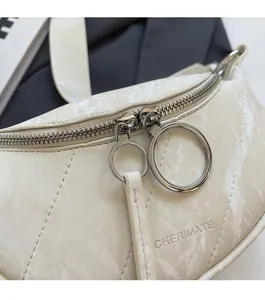 Close-up of cream textured leather bag with signature metal zippers and long pull tabs