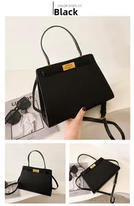 Détail du sac à main en cuir noir classique avec fermoir doré et poignée supérieure