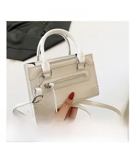 Vue de dessus d'un sac à main blanc crème structuré avec double poignées et détail de gland