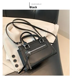 Vue détaillée du mini sac noir avec fermetures éclair métalliques et poignée supérieure