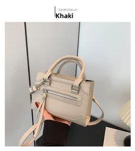 Détail du sac à main kaki en cuir avec pampille zippée et double poignée pour porté croisé