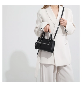 Détail du sac bandoulière noir avec ferrures argentées et bandoulière réglable en cuir