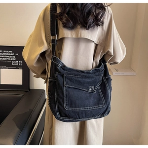 Dettaglio borsa a tracolla in denim nero con cuciture a contrasto e fibbia regolabile