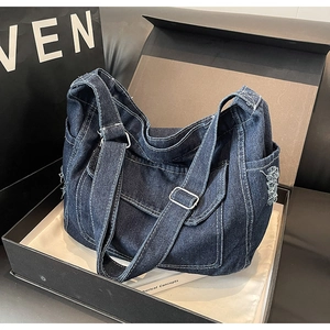 Dettagli della borsa a tracolla in denim blu con frange usurate e fibbie argentate