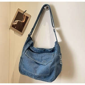 Dettaglio borsa a tracolla in denim con tasca frontale, tasca laterale e tracolla regolabile