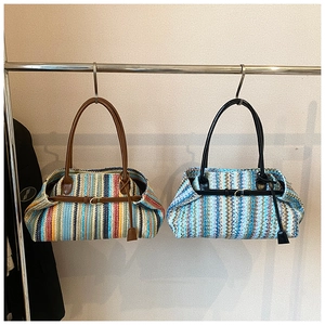 Detail of colorful knitted striped tote bags with leather straps hanging on a metal rack