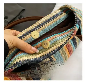Close-up of golden magnetic buckle and straw woven texture with striped patterns