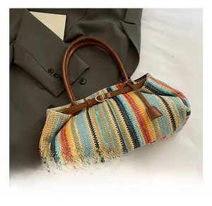Detail of colorful striped woven straw bag with brown leather handle and gold buckle