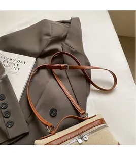 Détail de la bandoulière réglable en cuir et boucle métallique du sac en toile