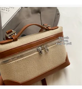 Détail du sac boîte en paille et cuir marron avec double fermeture éclair argentée fluide