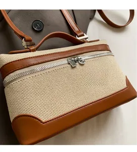 Gros plan du sac en toile avec bordures en cuir marron et fermeture éclair argentée