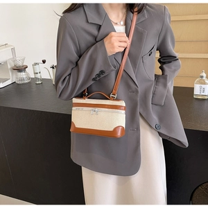 Détail du mini sac en toile vintage avec bordure en cuir marron dans un café