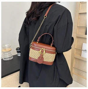 Close-up of handmade bamboo woven crossbody bag with brown leather flap and metal zipper