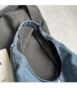 Gros plan de la bandoulière large en denim bleu avec des coutures solides et durables