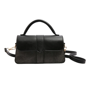 Minimalistische zwarte leren handtas met klep en goudkleurige hardware riem