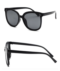 Détail de lunettes de soleil noires polarisées avec trois rivets métalliques décoratifs